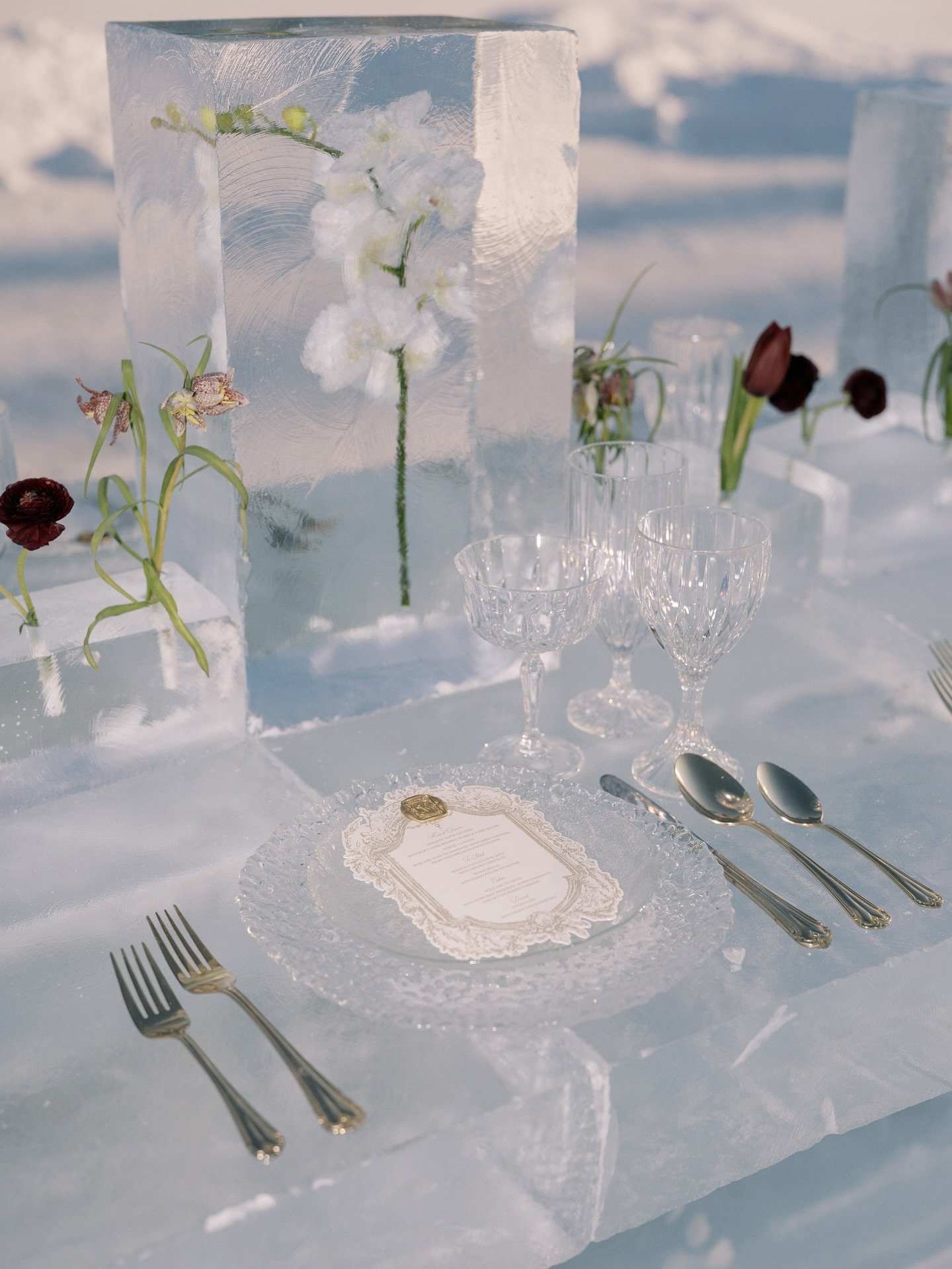 Close-up of ice table place setting with flowers frozen in ice centrepiece