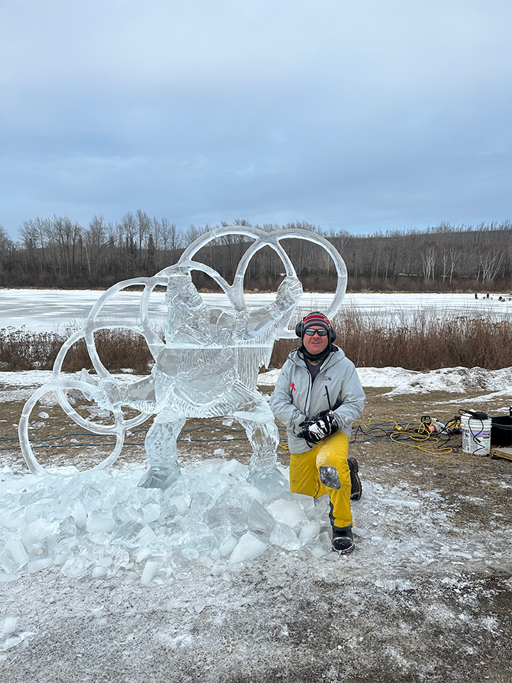 Sculptor posing with hoop dancer ice sculpture