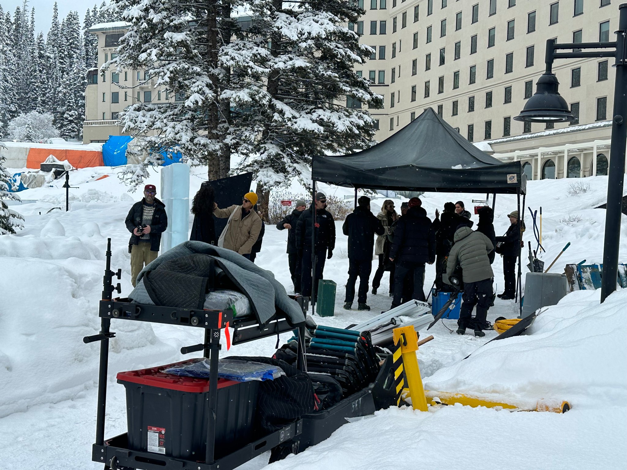 Camera operator and crew working around the ice bar and MK logo sculpture — full production underway