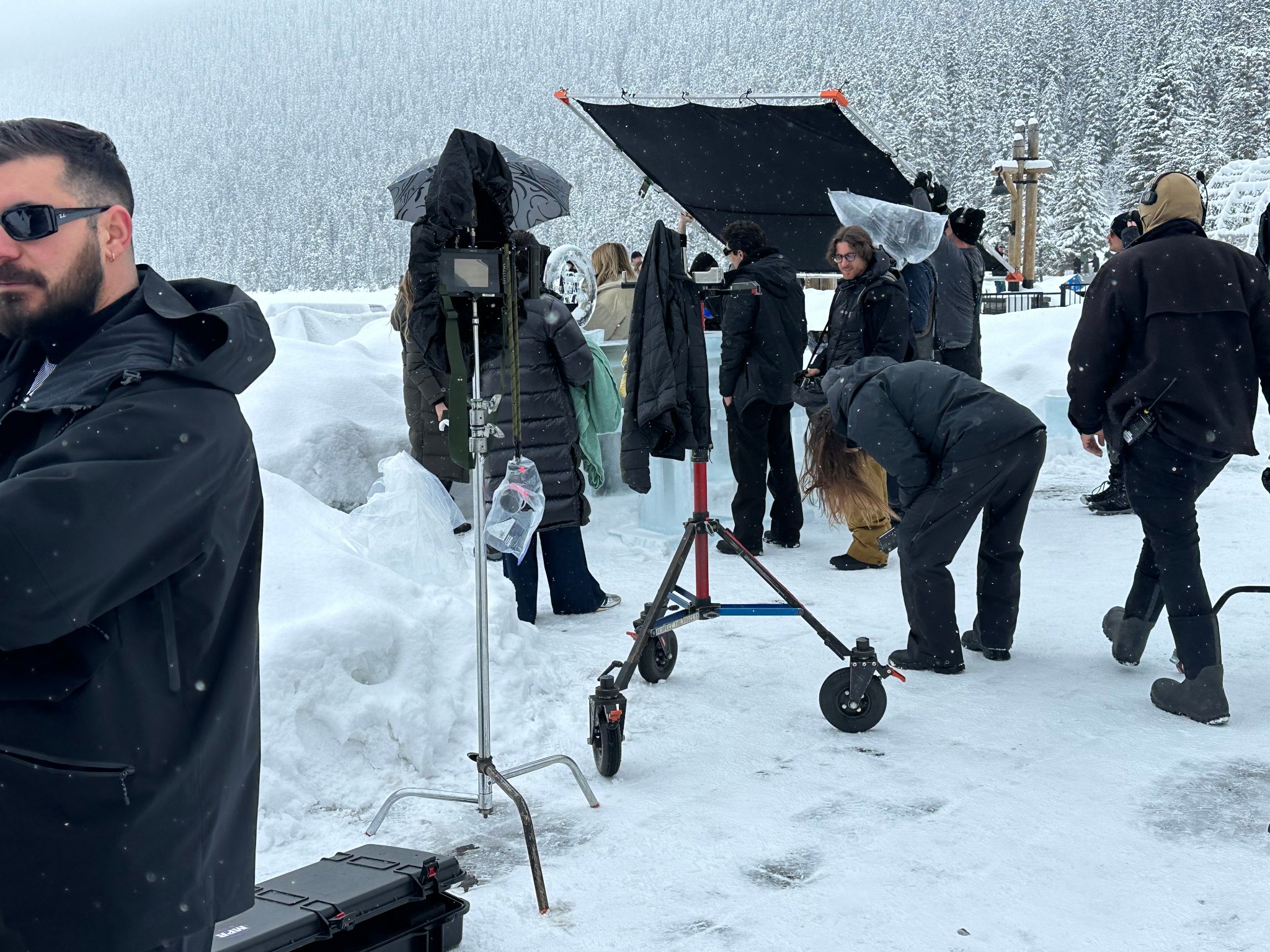 Photographers shooting model against ice column at Lake Louise — Fairmont Chateau visible in background